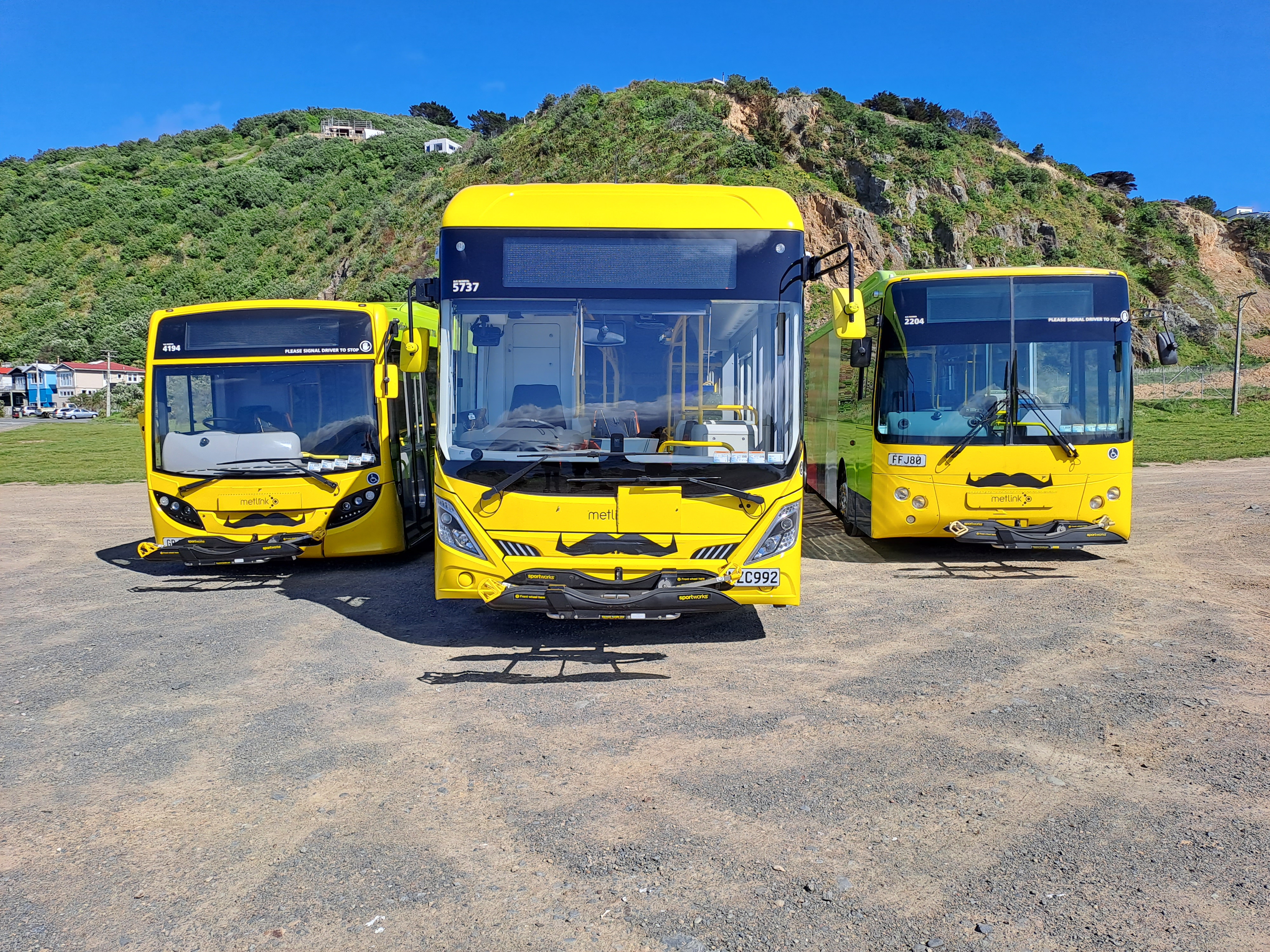 Three Metlink buses with moustaches on their front