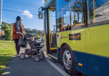 Woman with child in pram boarding bus